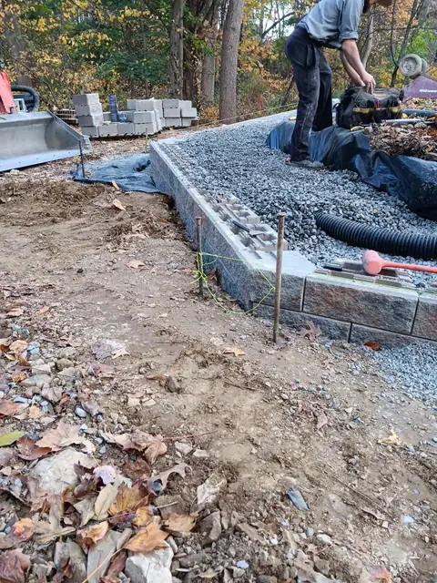 Retaining wall base course on gravel and fabric