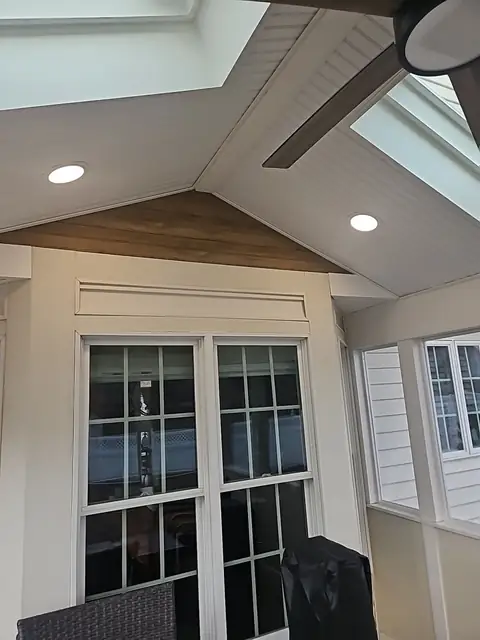Enclosed porch interior with French doors and recessed lights