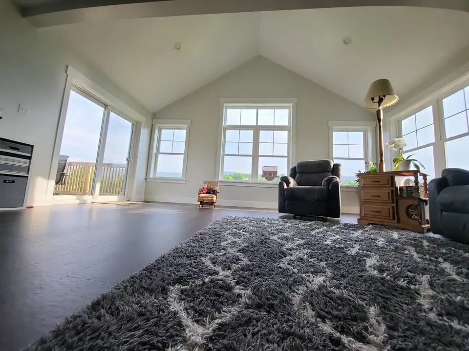 Sunroom interior with a vaulted ceiling and walls of windows