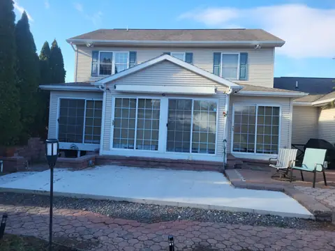 Sunroom with a gable roof and sliding glass doors onto a concrete patio