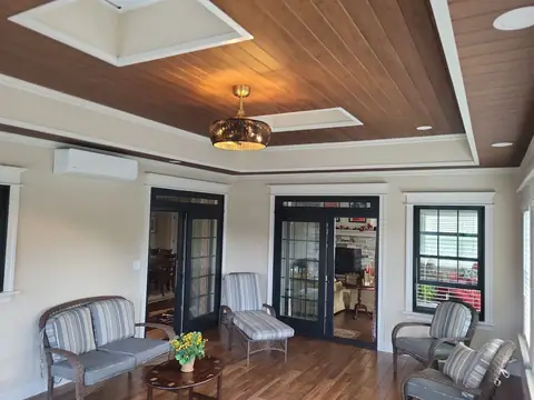 Sunroom interior with a wood ceiling, French doors and a pendant light