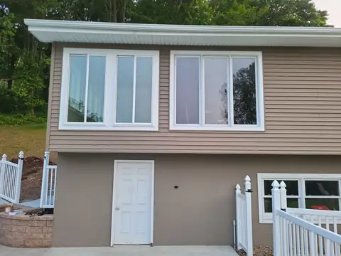 Sunroom exterior with a row of windows above a walkout door
