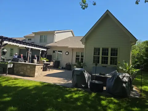 Black pergola over a paver patio with an outdoor kitchen