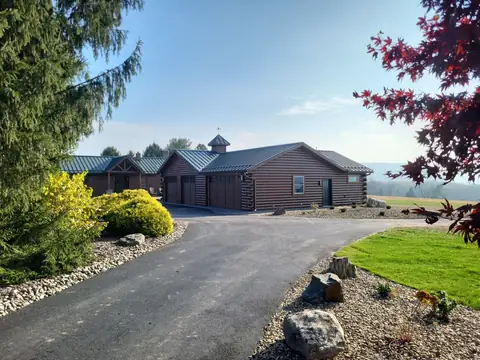 Log-sided three-car garage with a metal roof and a cupola