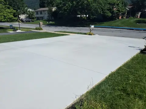 New concrete driveway with control joints at the lawn edge