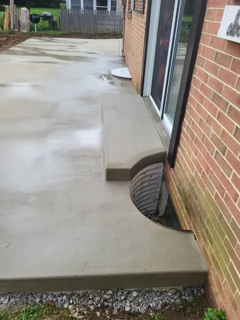 Concrete patio step landing at a sliding door