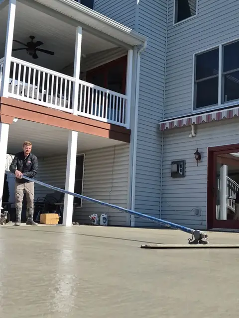Crew screeding a fresh concrete patio