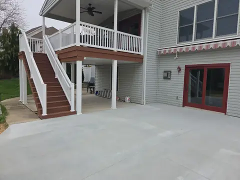 Large concrete patio under a two-story deck