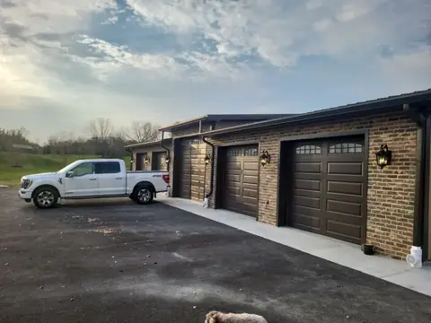 Garage with a brick front and three brown overhead doors