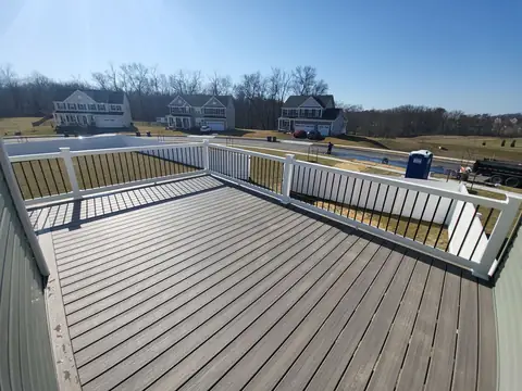 Gray deck boards with white railing and black balusters