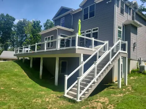 Second-story composite deck with white vinyl railing and stairs