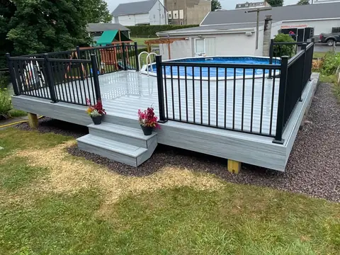 Above-ground pool deck with black aluminum railing and steps