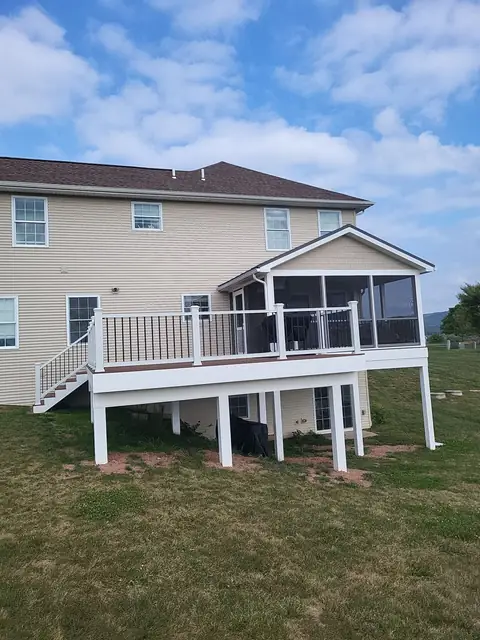 Raised deck and screened porch with white railing and stairs