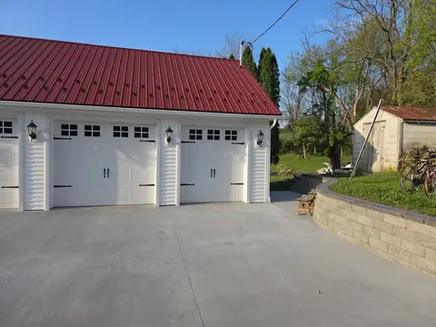 Concrete driveway and three-car garage beside a retaining wall