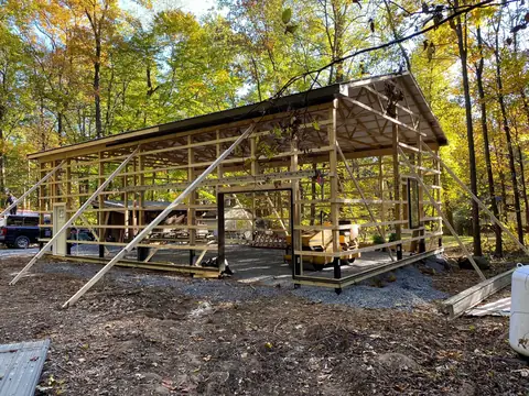 Pole barn posts and trusses being framed