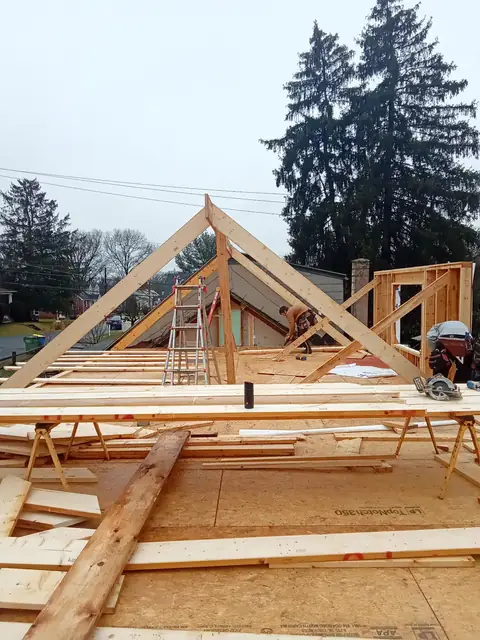 Roof trusses being set on addition wall framing